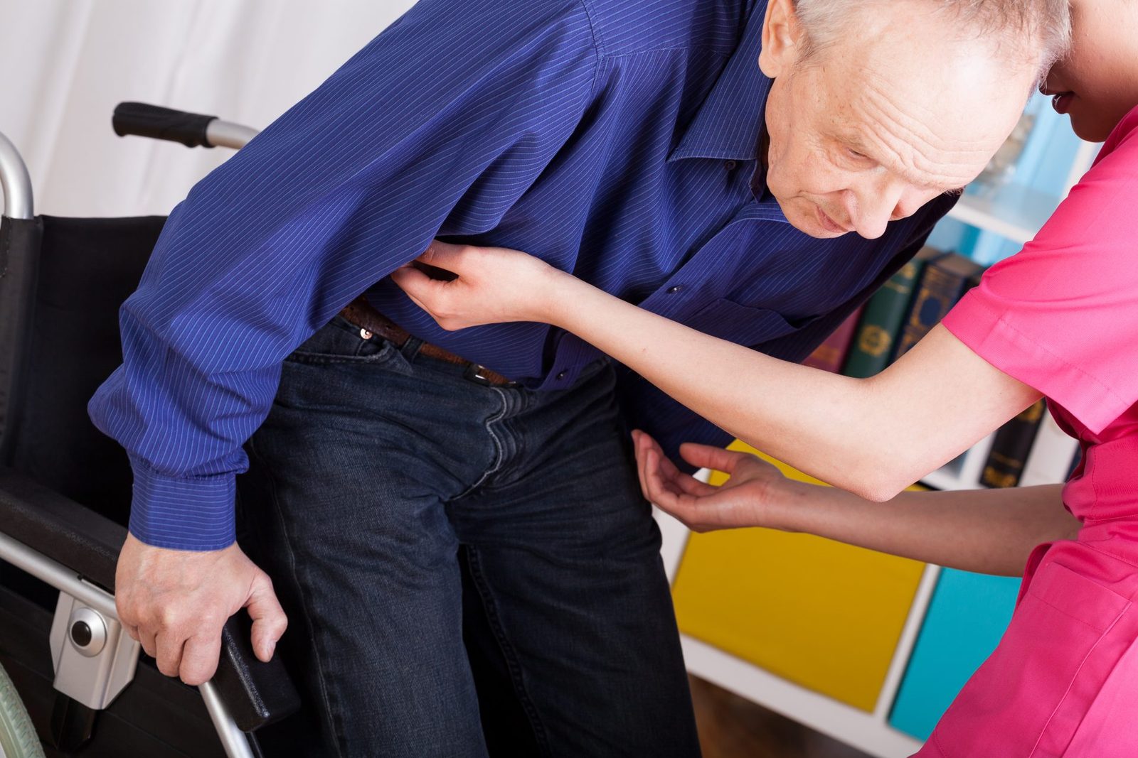 A nurse manually lifting a senior citizen